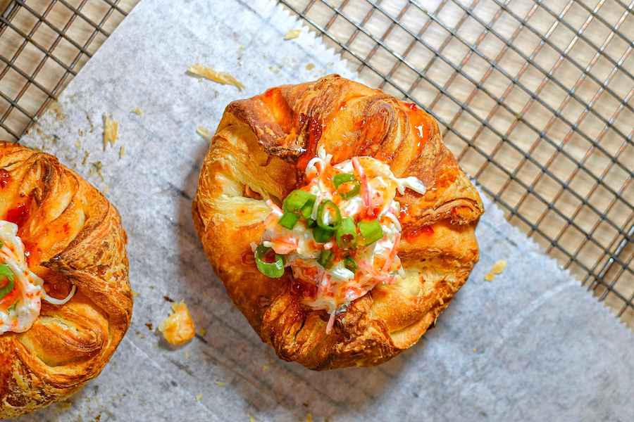 Savory puff pastry tarts with bacon and herbs on a wire rack